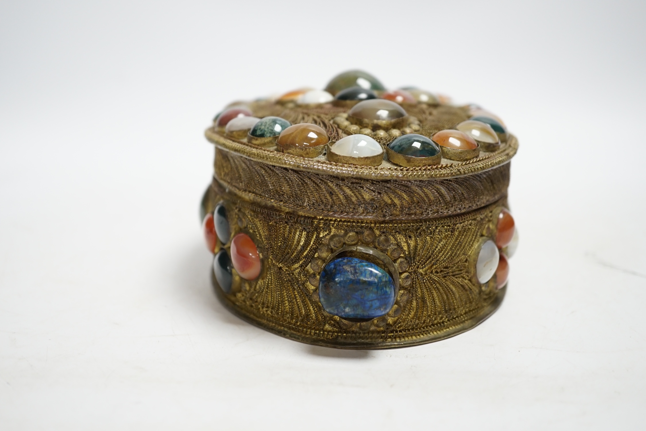 A brass filigree work and agate cabochon mounted oval box, 19cm wide